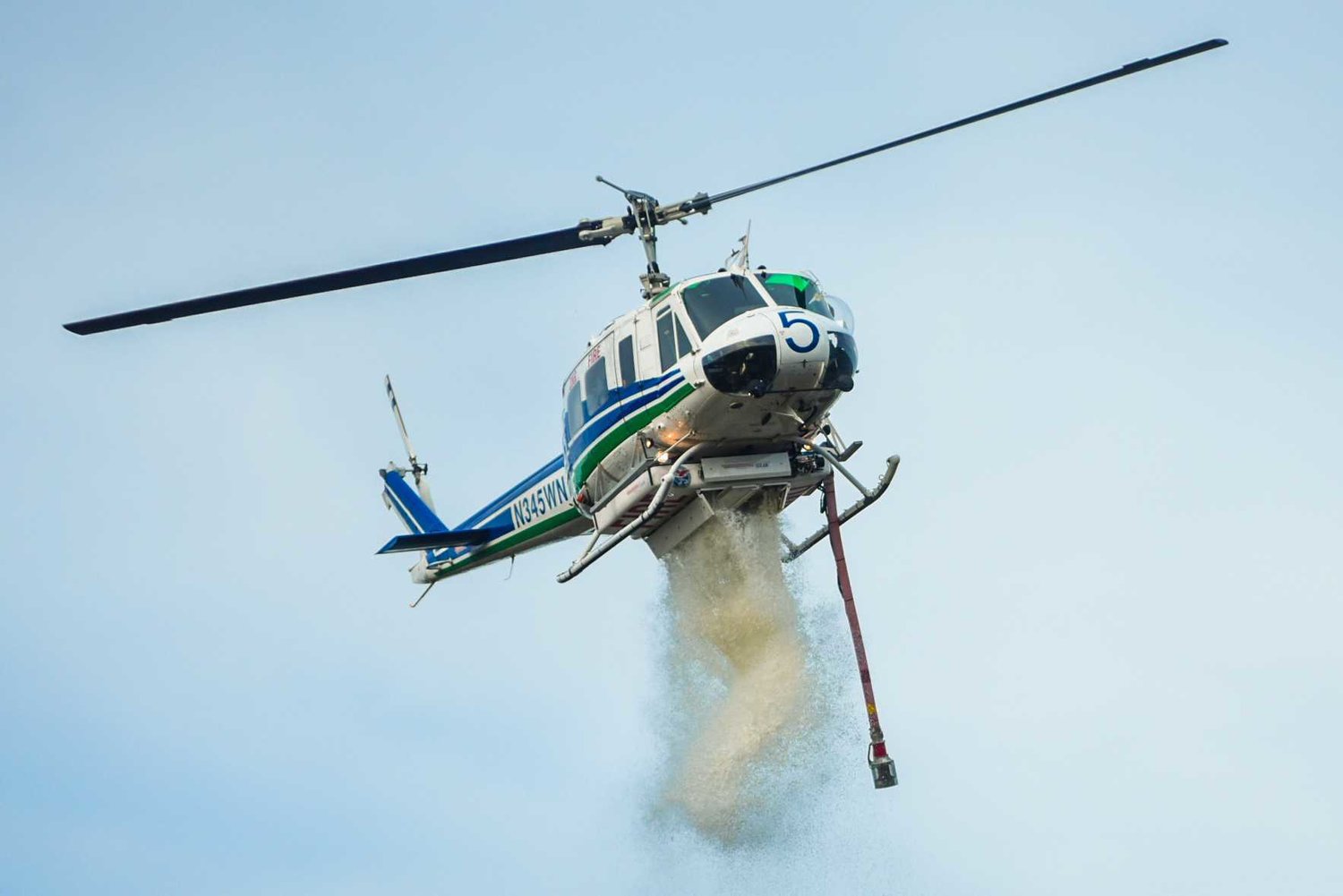 A DNR helicopter drops water on a brush fire in Doty last April.