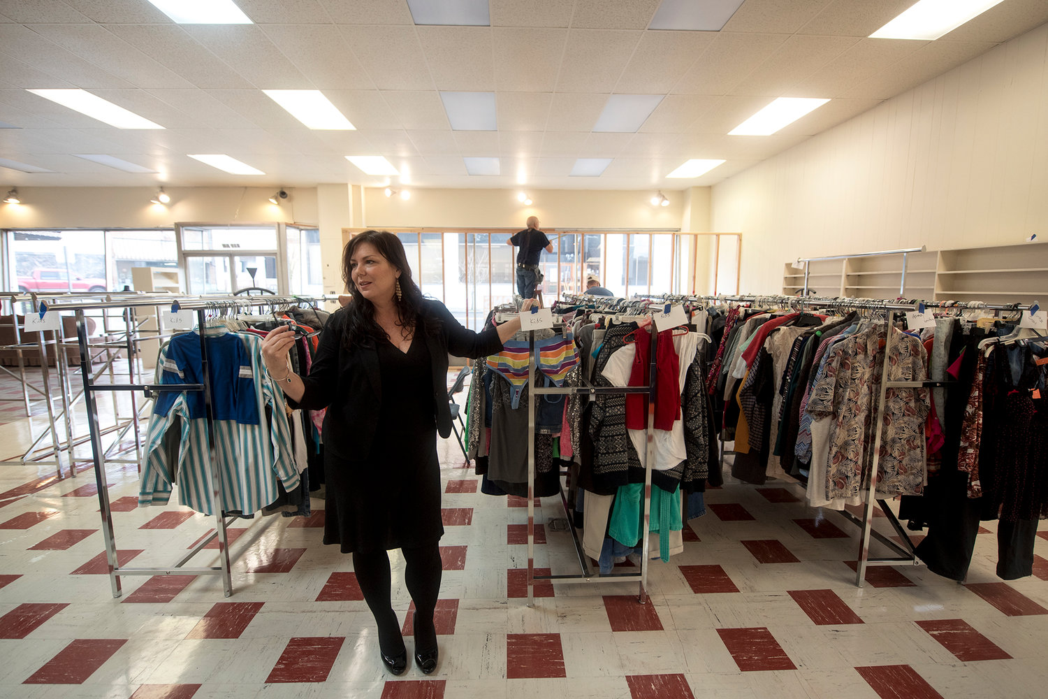In this Jan. 22, 2016 file photo, Visiting Nurses Foundation Executive Director Jenny Collins stands in front of racks of donated clothing as workers complete the front window display area at the new Visiting Nurses thrift shop in downtown Chehalis.