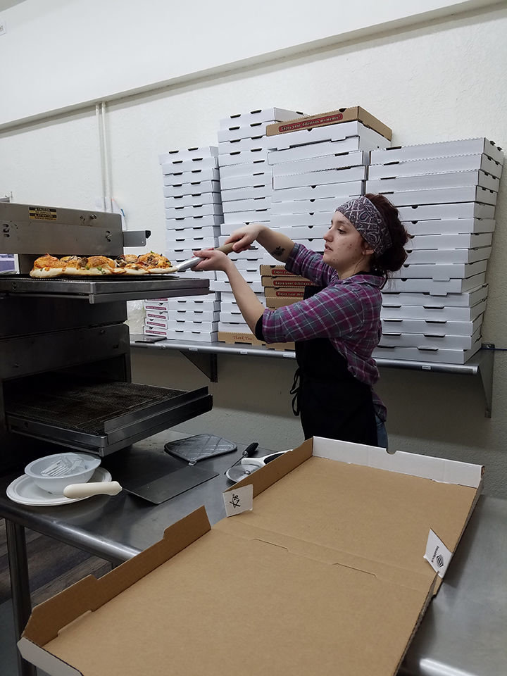 Kaitlyn Bornstein lifts a pizza out of a convection oven at Maverick's Pizza in Centralia. The restaurant on Main Street opened to the public on Feb. 1 and has seen steady business since.