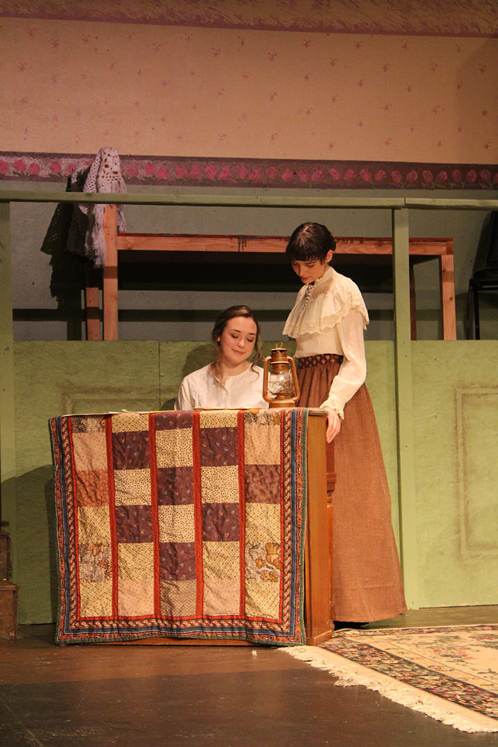 Meg, portrayed by Isabel Nixon Klein, looks on as her sister Beth, portrayed by Kirsten Scogin, plays the piano in "Little Women" opening Feb. 14 at the Roxy Theatre in Morton.