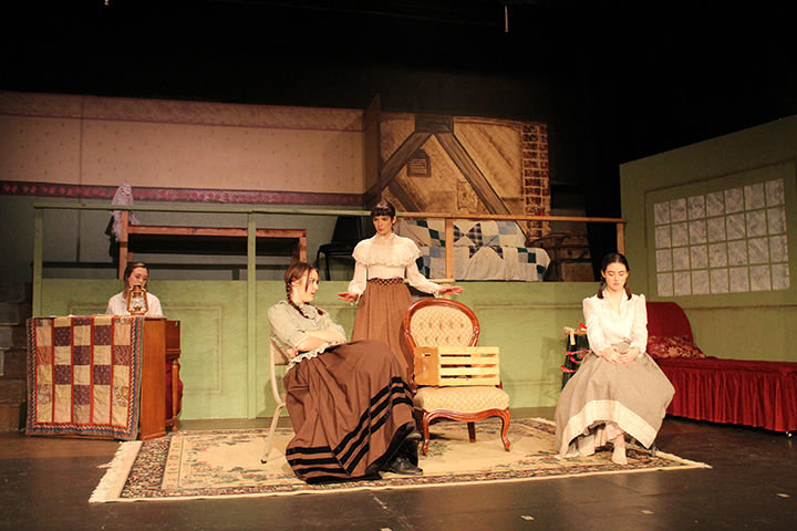 Meg, portrayed by Isabel Nixon Klein, intervenes in a spat between the hard-headed Jo, portrayed by Scarlet Nixon Klein, and Amy, portrayed by Talia Heath as Beth, portrayed by Kirsten Scogin, looks on from her piano in "Little Women" opening Feb. 14 at the Roxy Theatre in Morton.
