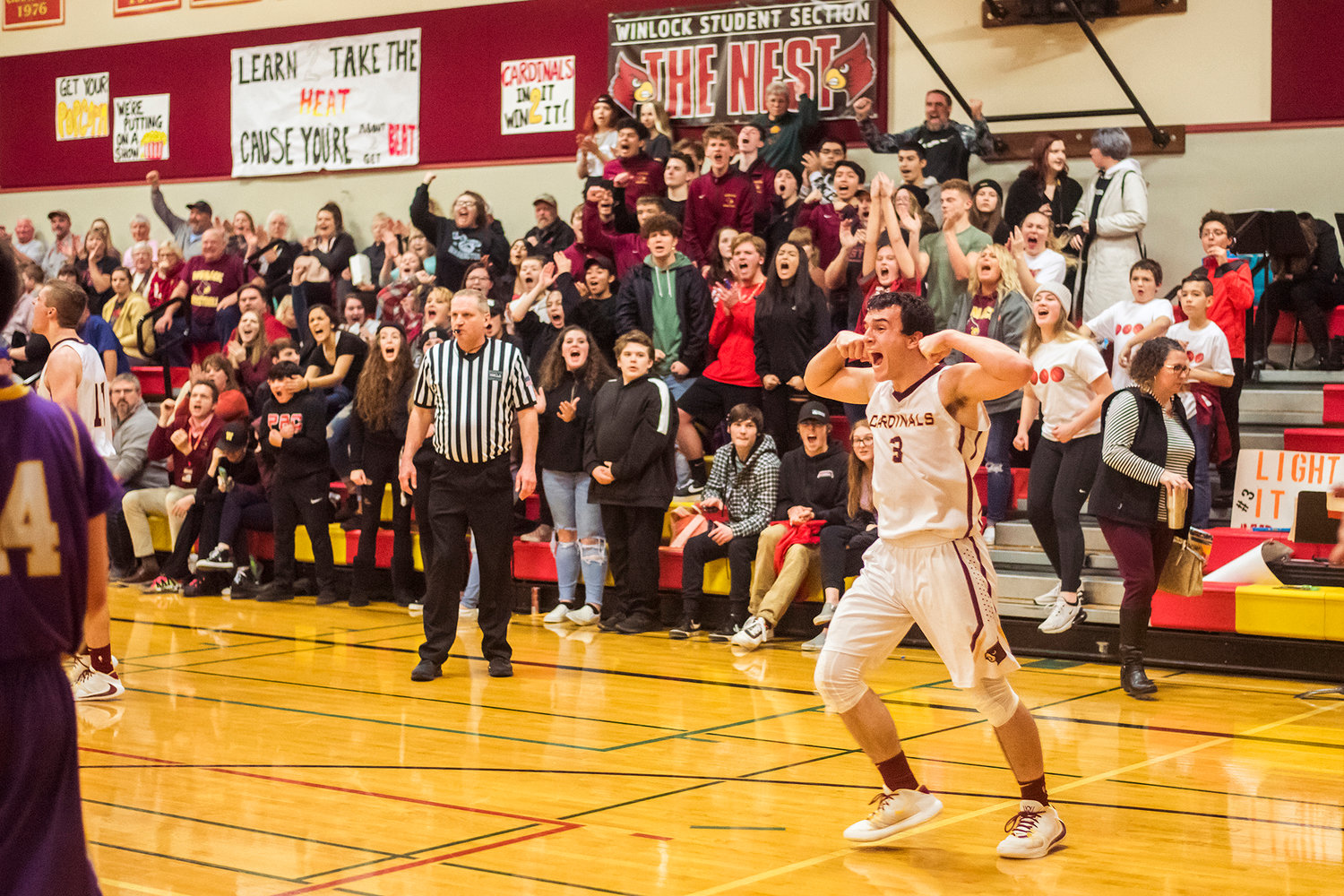 Cardinal's Bryce Cline (3) cheers in front of 'The Nest' Wednesday night at Winlock High School.