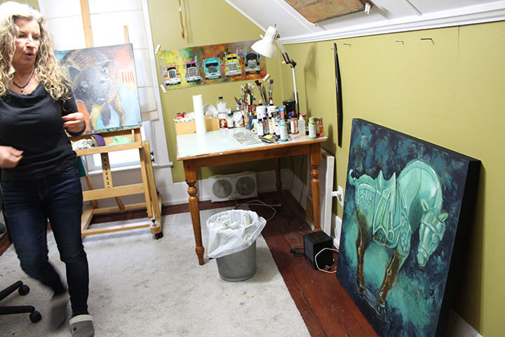 Sue Darius in her attic space studio next to a painting in a series she is working on inspired by Tang dynasty bronze horses. Darius said she likes how the large, rectangular horses are balanced on small, square pedestals.