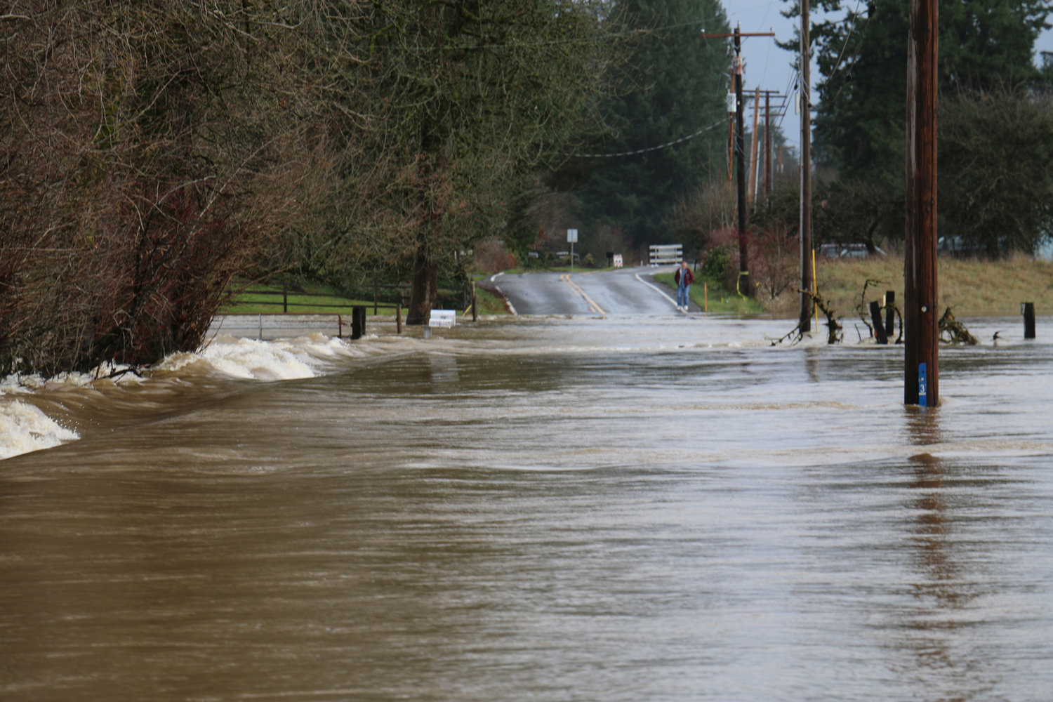 A person looks at the fast moving water that swept over Independence Road in this file photo.