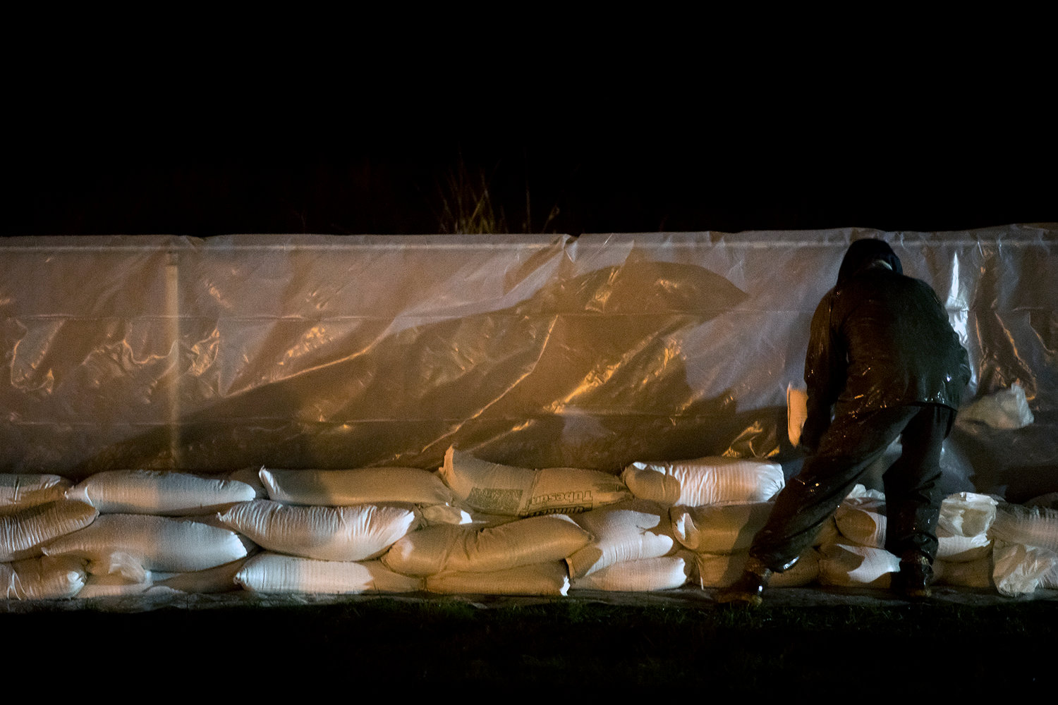Workers put up sandbags along a fence line near Chehalis Avenue in this file photo.