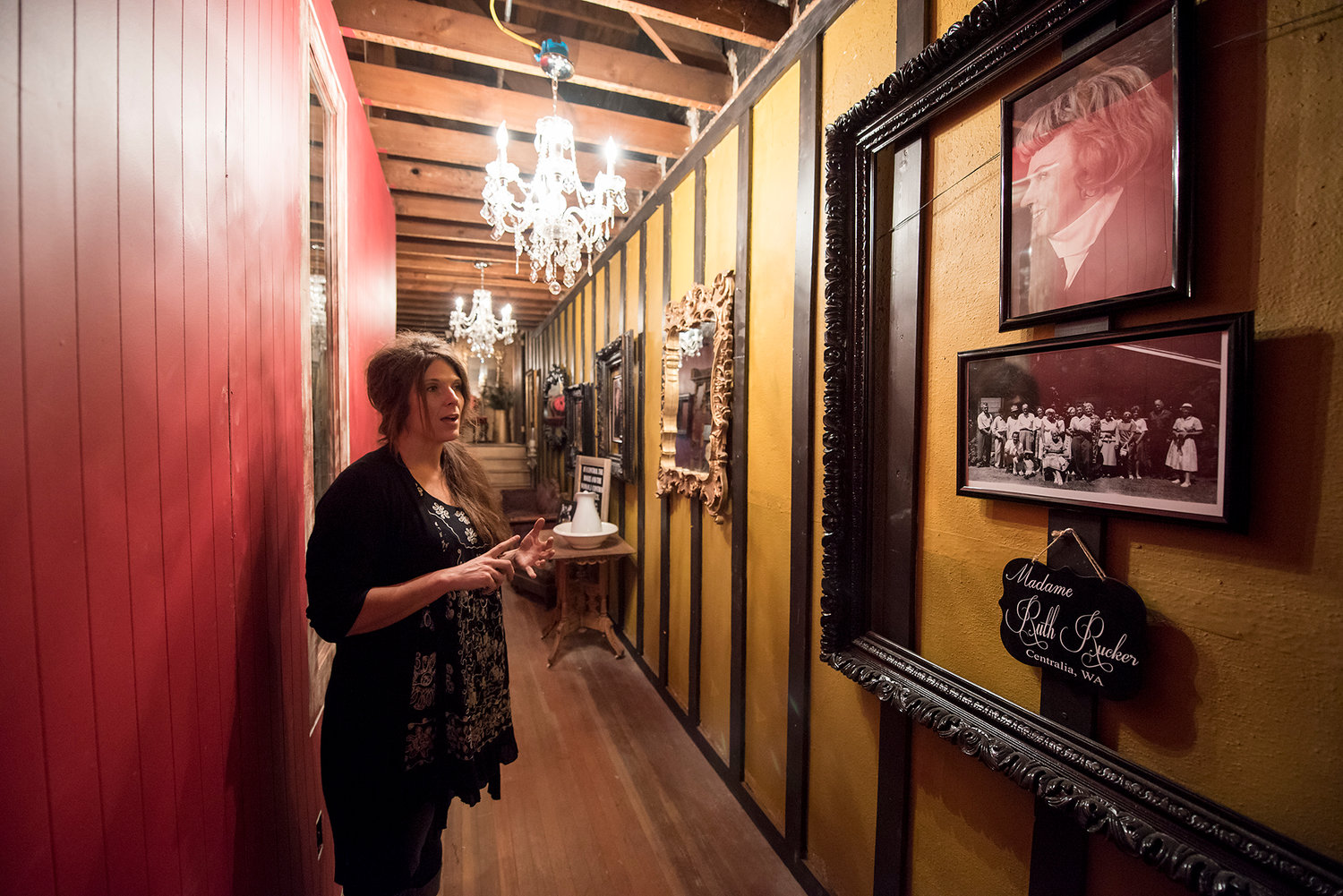 FILE PHOTO — Holly Phelps, owner of the Shady Lady in downtown Centralia, stands in the narrow hallway adorned with pictures of Madame Ruth Rucker, who ran a brothel in Centralia in the early 20th century, while giving a tour of her new Bordello Museum.