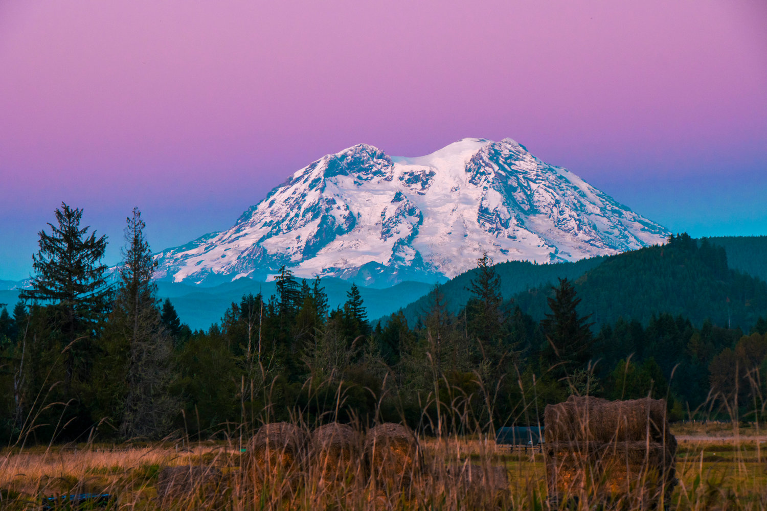 Mount Rainier beacons above foothills at sunset seen from Highway 7.