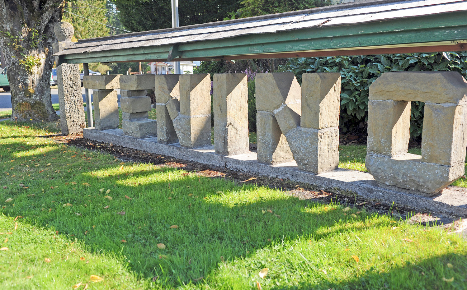A sign made of rock spells out Tenino in front of the City Hall building.