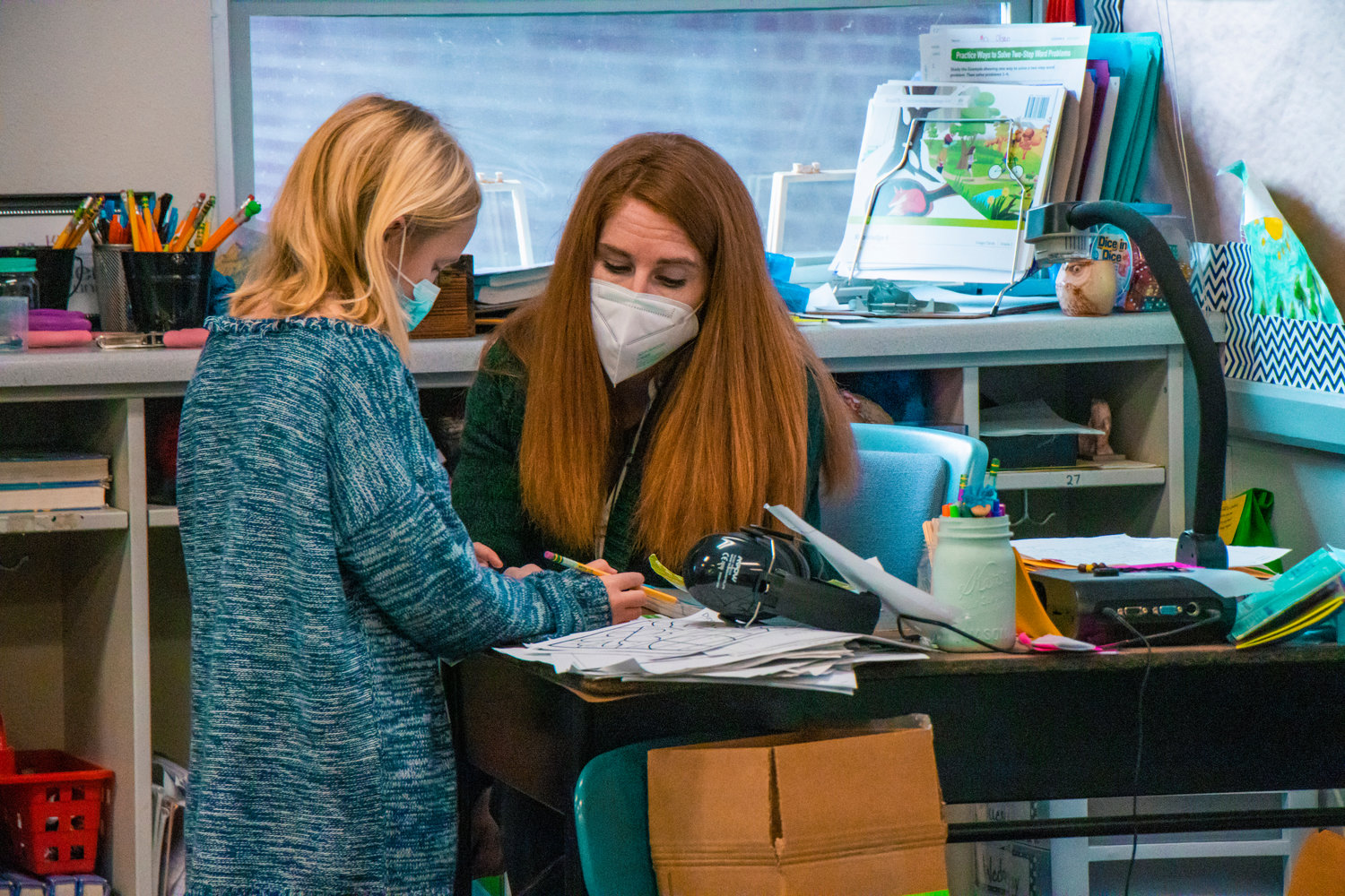 An Onalaska teacher sports a mask as she works with a student on Tuesday.