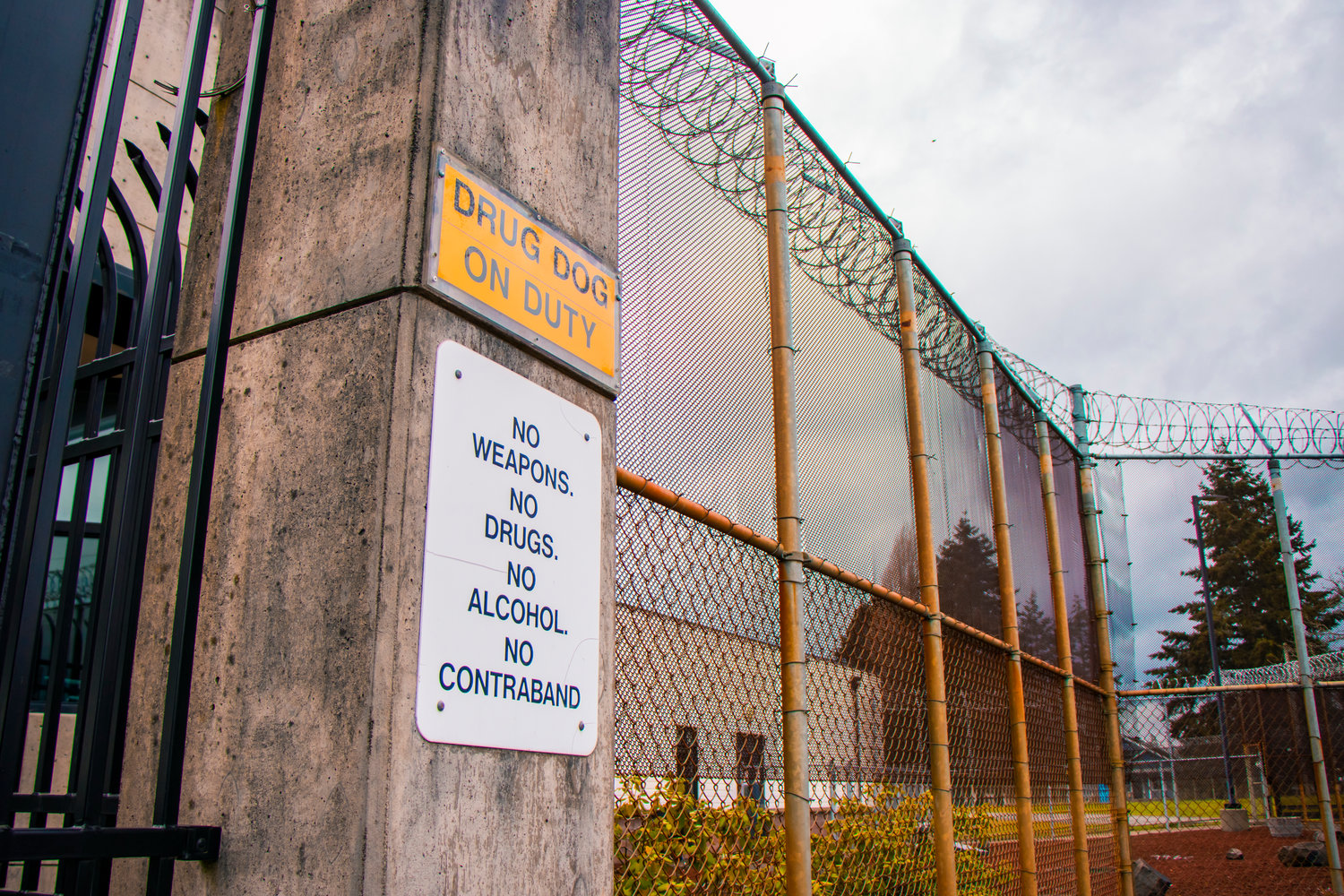Signage prohibits weapons, drugs, alcohol and contraband within the fences lined with razor wire around the Green Hill School in Chehalis on Friday.