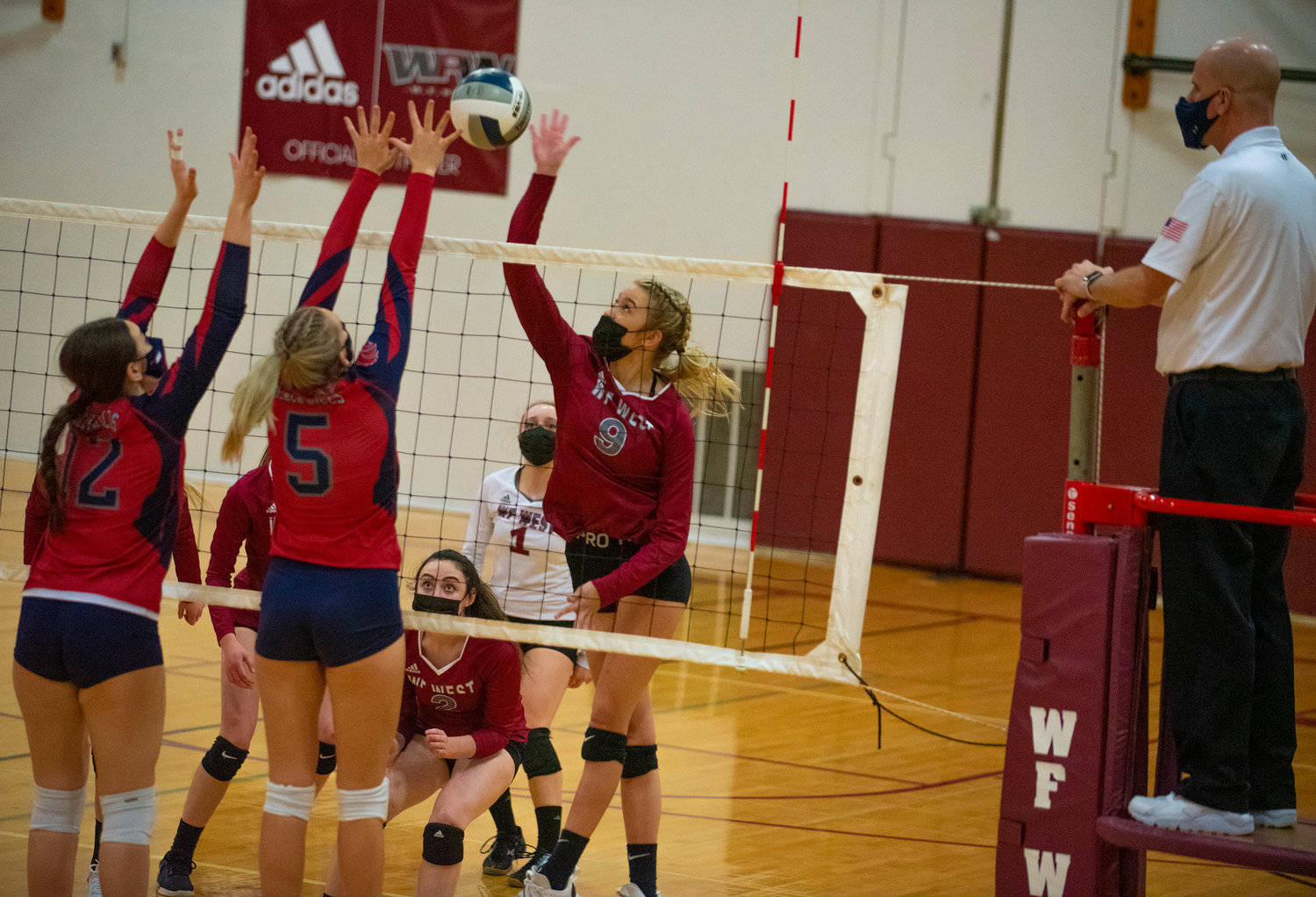W.F. West junior Ava Olsen (9) spikes theball against Black Hills' Payton Childers (12) and Olivia Hisaw (5) on Tuesday.