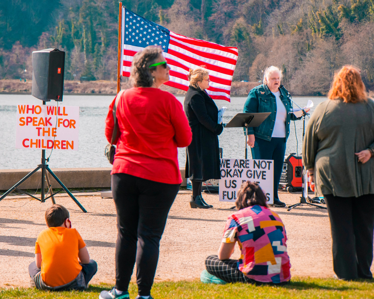 A sign reads, ‘Who will speak for the children’ during a rally in support of reopening schools to full in-person learning near Capitol Lake in Olympia on Saturday.