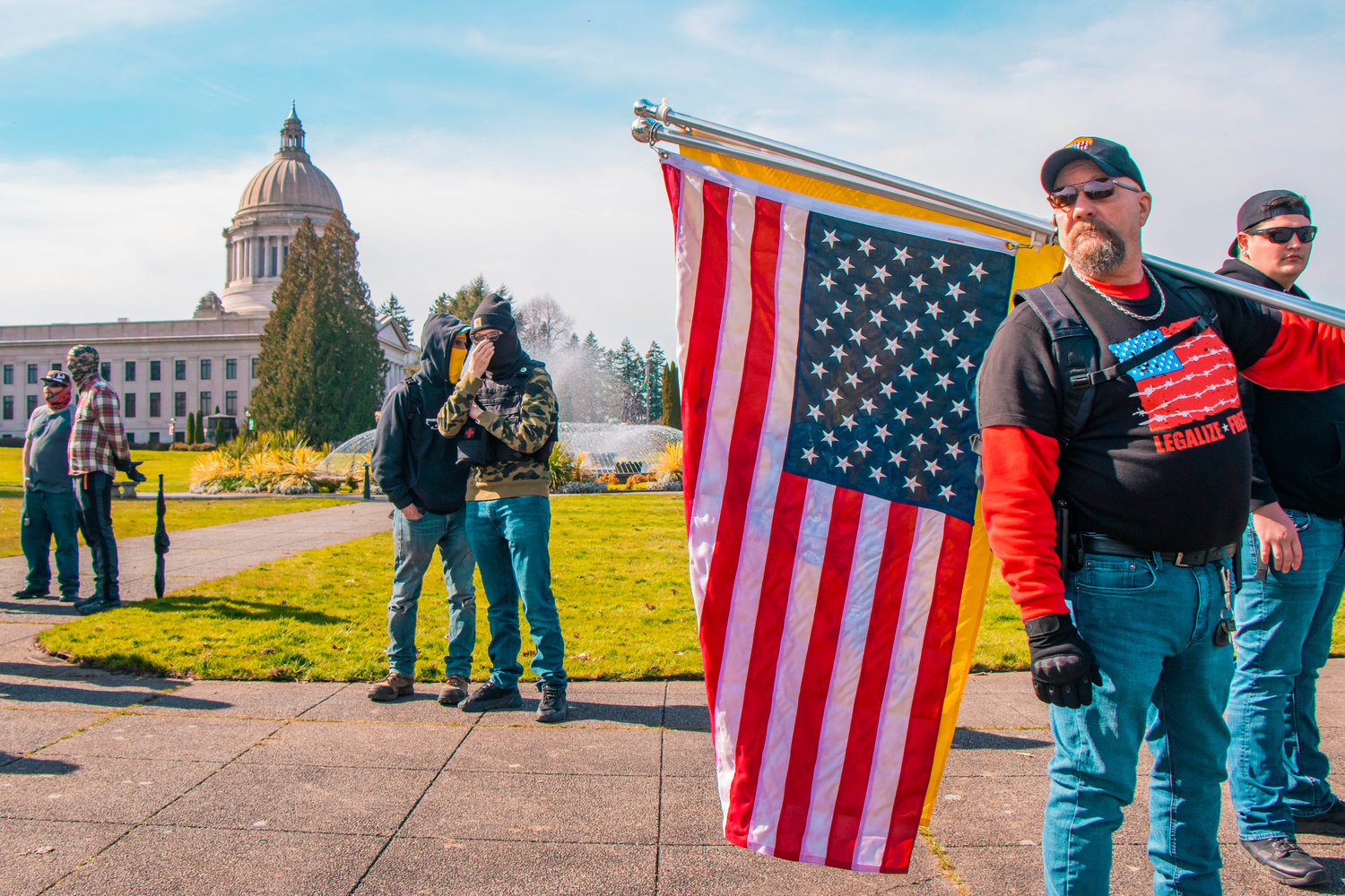 Flags are waved by attendees of a rally in support of open carry near the Washington State Capitol in Olympia on Saturday.