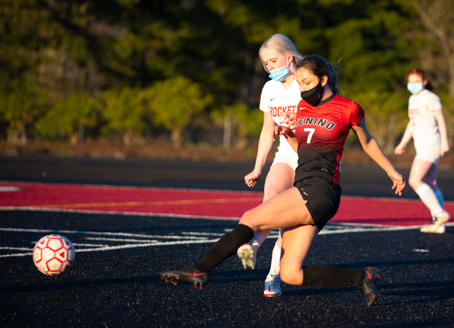 Tenino junior Emma Barr (7) boots the ball away from the sideline against Castle Rock's Elieriq Cole on Monday.