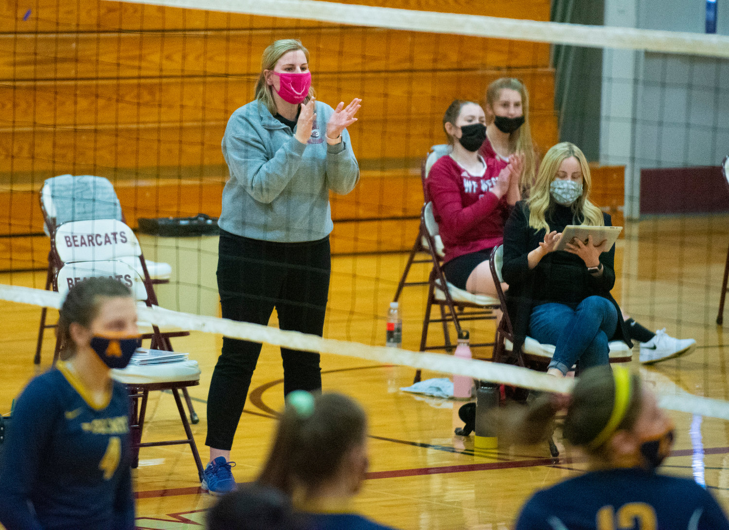 W.F. West coach Emily Mora applauds her team after scoring a point during the third set on Tuesday.