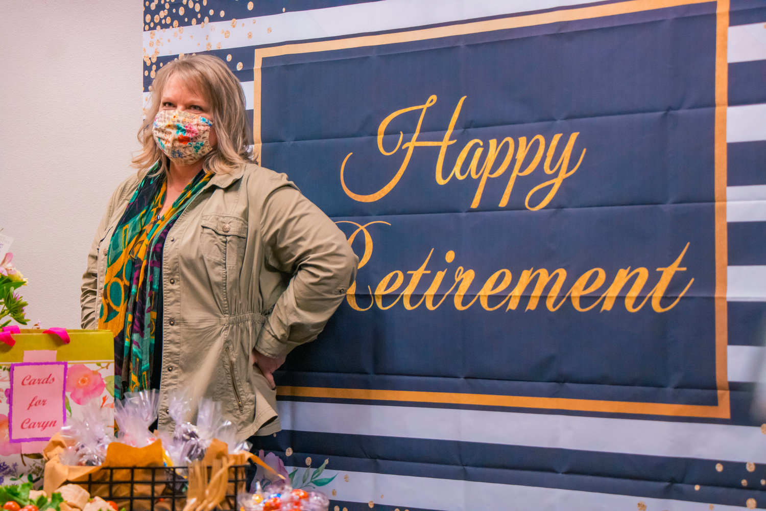 Caryn Foley stands in front of a banner that reads "Happy Retirement" on Tuesday in Chehalis.