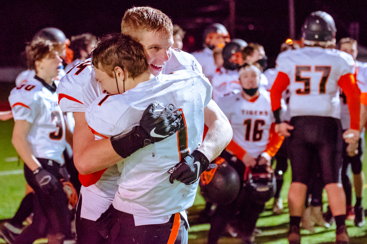 Napavine's Cade Evander (34) and Laythan Demarest (1) smile and embrace following a game against Onalaska Saturday night at Tiger Stadium.