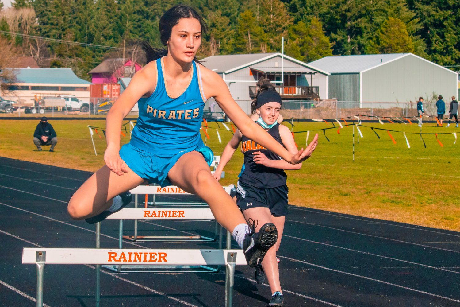 Adna’s Charissa Schierman jumps over hurdles during a track meet at Rainier High School on Thursday.