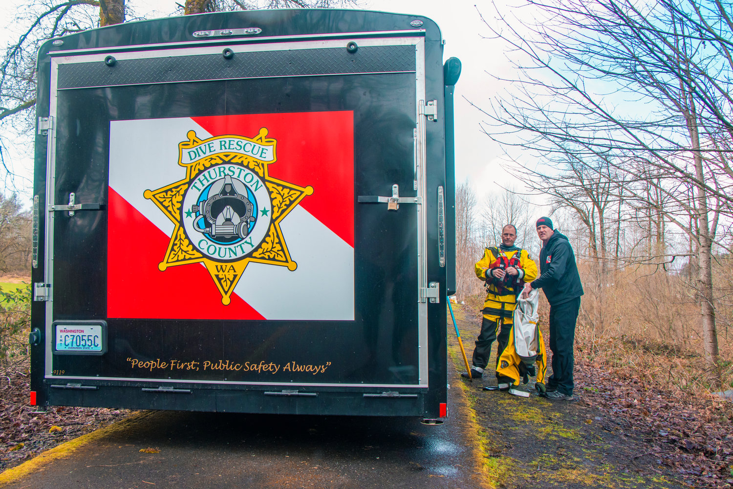 Members of the Thurston County Sheriff Dive and Rescue crew stand along the Willapa Hills Trail near the Chehalis River during a search for missing teen Zach Hines-Rager in Adna.