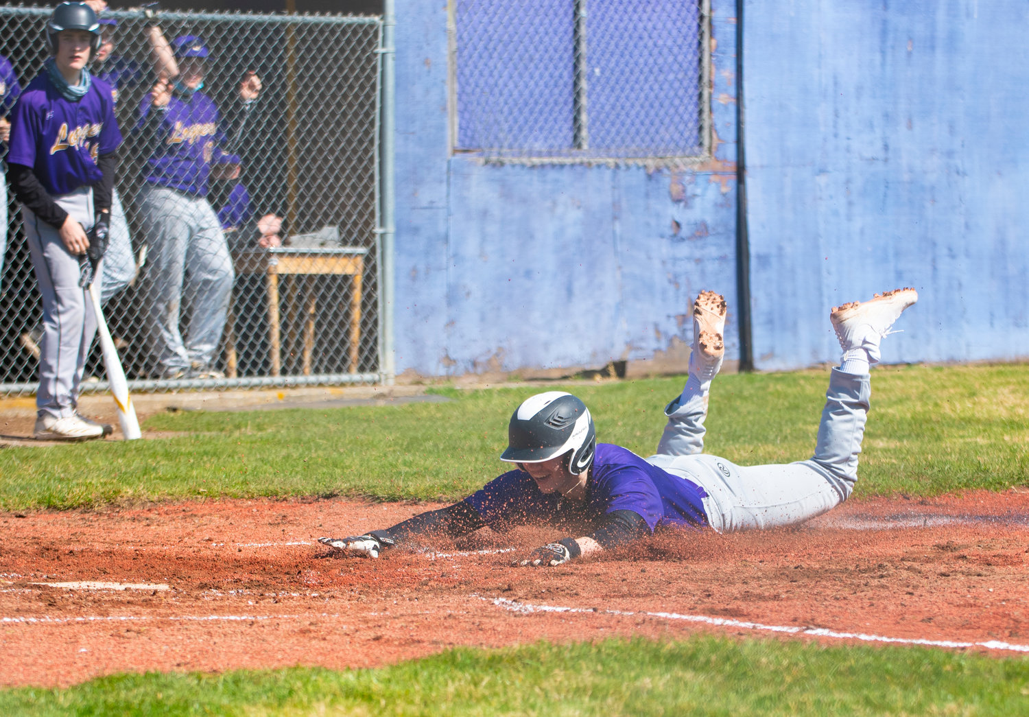 Onalaska's Danny Dalsted dives headfirst into home plate to give the Loggers a 1-0 lead over Toledo in the first inning at home Friday.