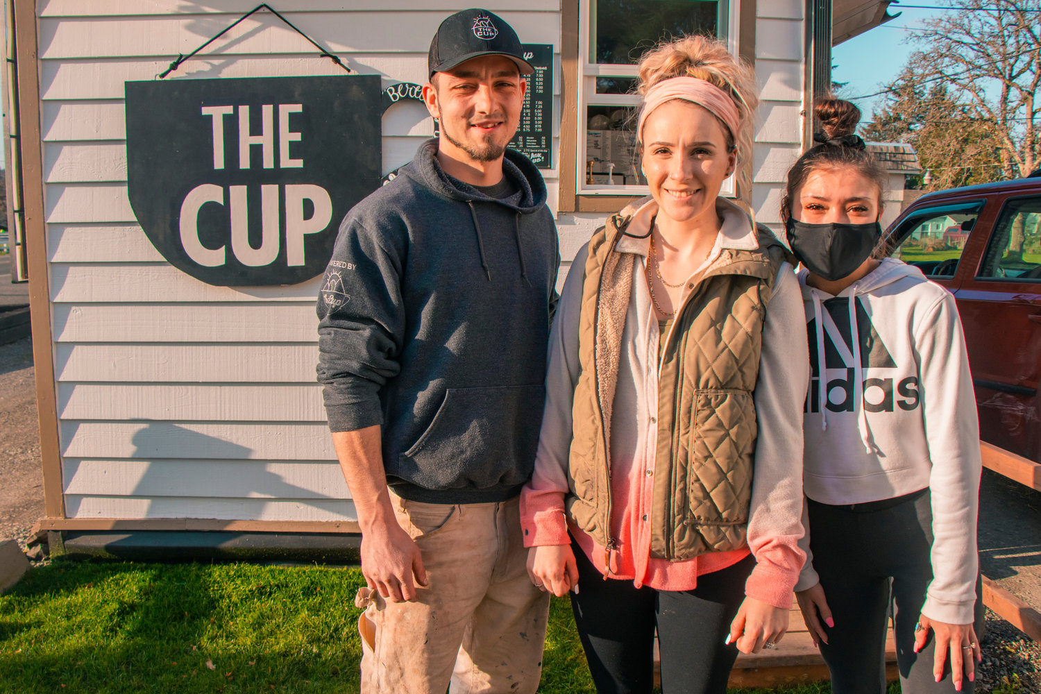 From left to right, Marco Bertucci and Jessi Gilliam, owners of The Cup in Centralia, and employee Alyssa Dougherty pose for a photo outside their coffee stand on Tuesday.
