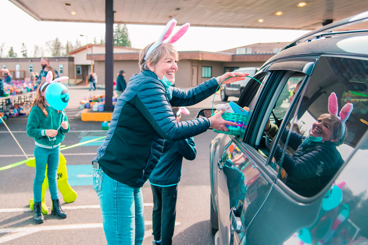 Pat Soderquist smiles as she hands out an Easter basket at Bethel Church on Saturday while sporting bunny ears.