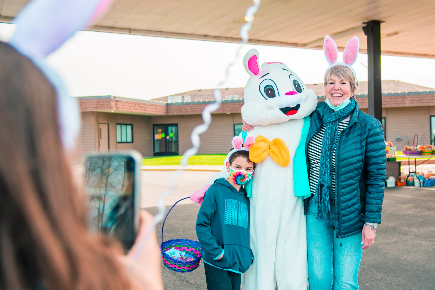 Sophia takes a photo as her brother Antonio and Pat Soderquist pose with the Easter Bunny at Bethel Church in Chehalis on Saturday.
