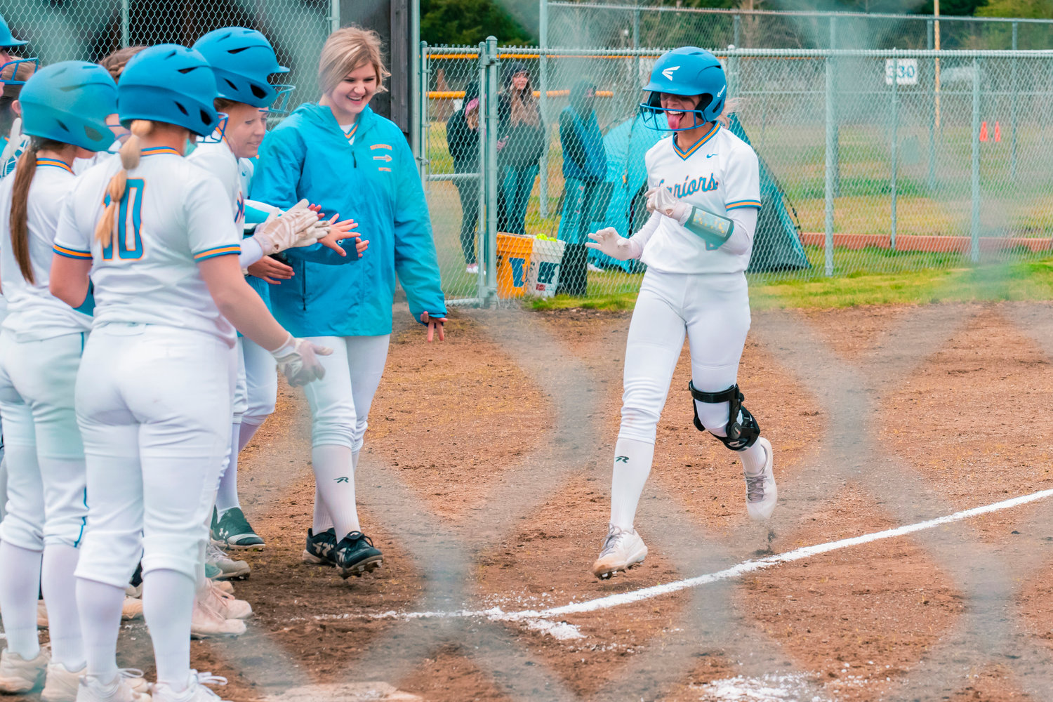 Rochester’s Sadie Knutson is met at home plate by teammates after hitting a home run Wednesday during a game against Centralia.