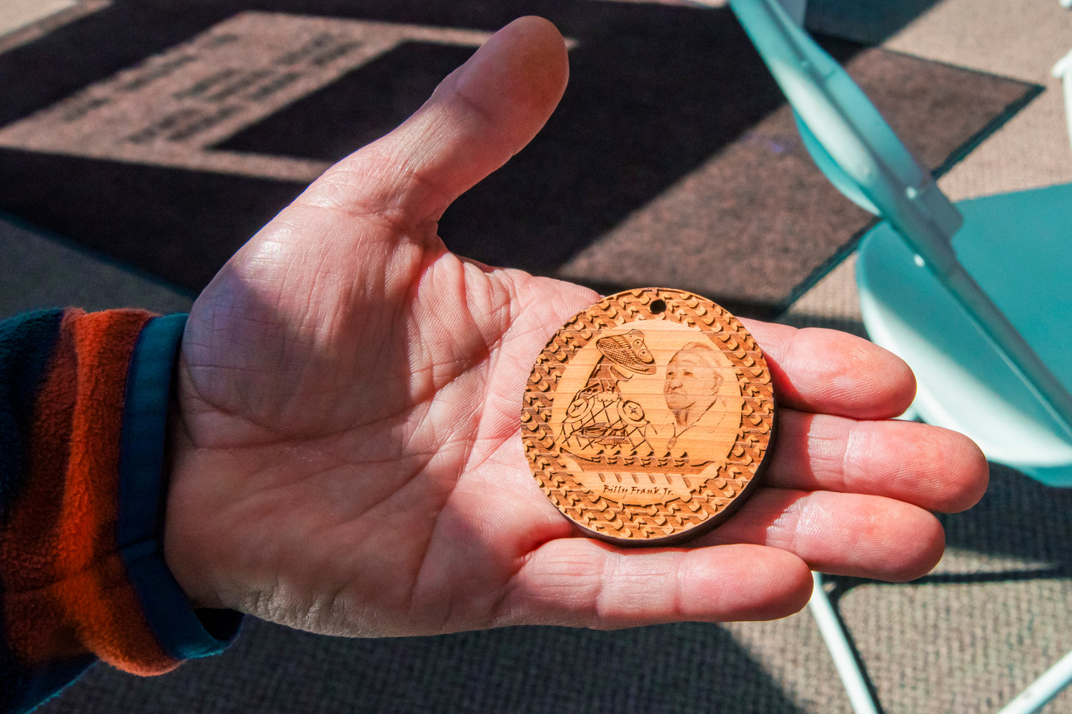 Kieth Brent, Senior Construction Project Manager with the Nisqually Tribe, holds a wooden medallion depicting Billy Frank Jr. Wednesday at the Wa-He-Lute Indian School.