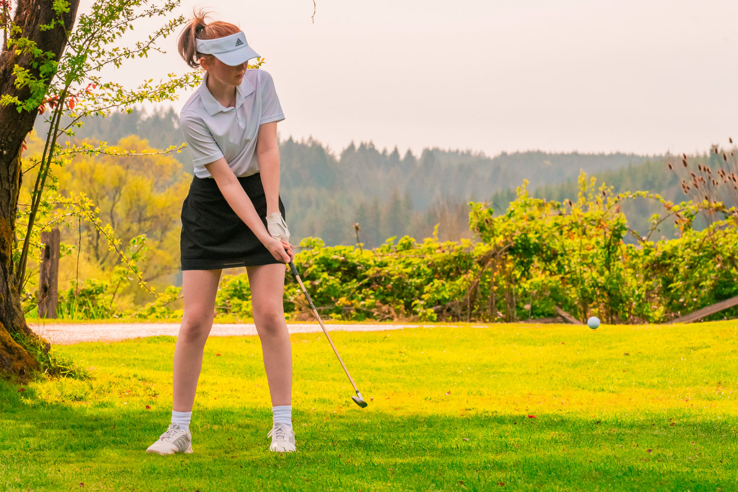 Centralia’s Samantha Johnston makes contact with her golf ball at Riverside Golf course in Chehalis on Monday.