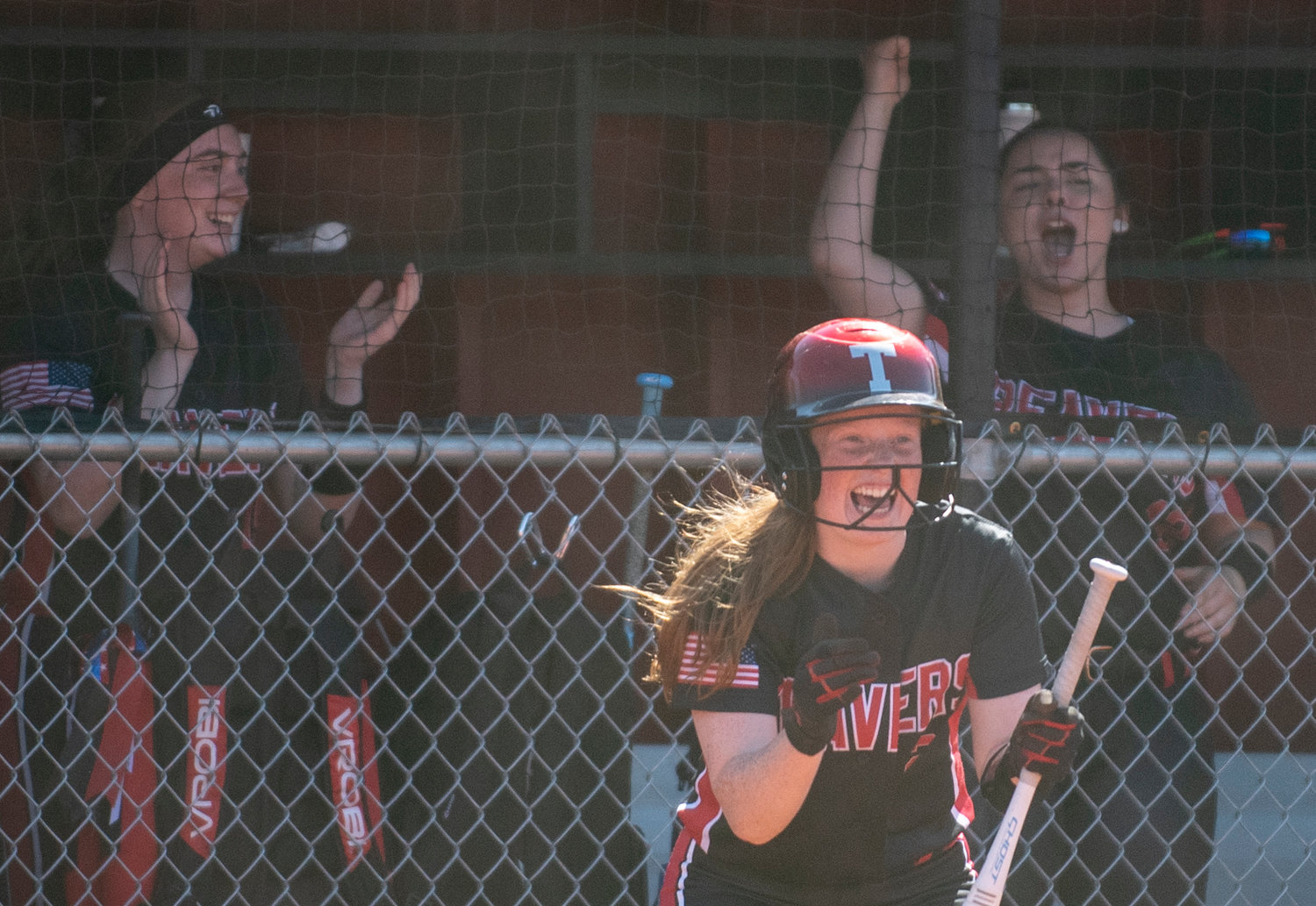 Tenino's Abby Severse, front, and the Beavers' dugout cheer on Lizzy Drisken after Drisken drilled an RBI single down the first base line against Elma on Tuesday.