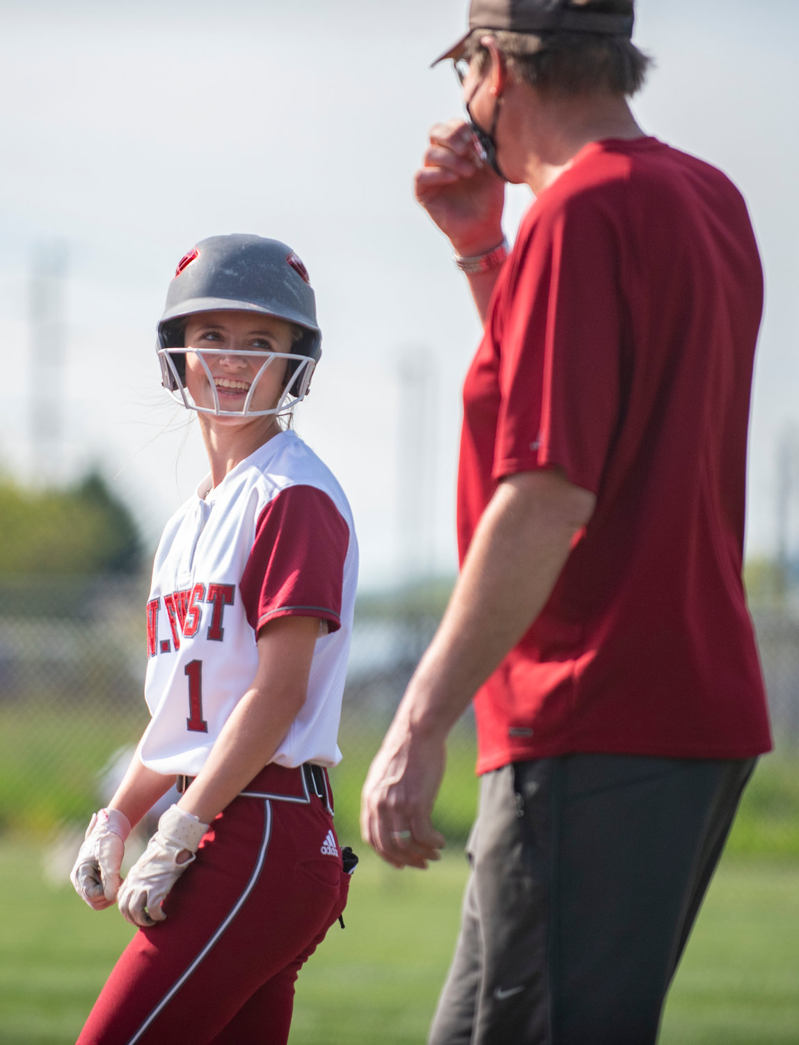 W.F. West sophomore Brielle Etter chats with the Bearcats' first-base coach after hitting a single against Tumwater.