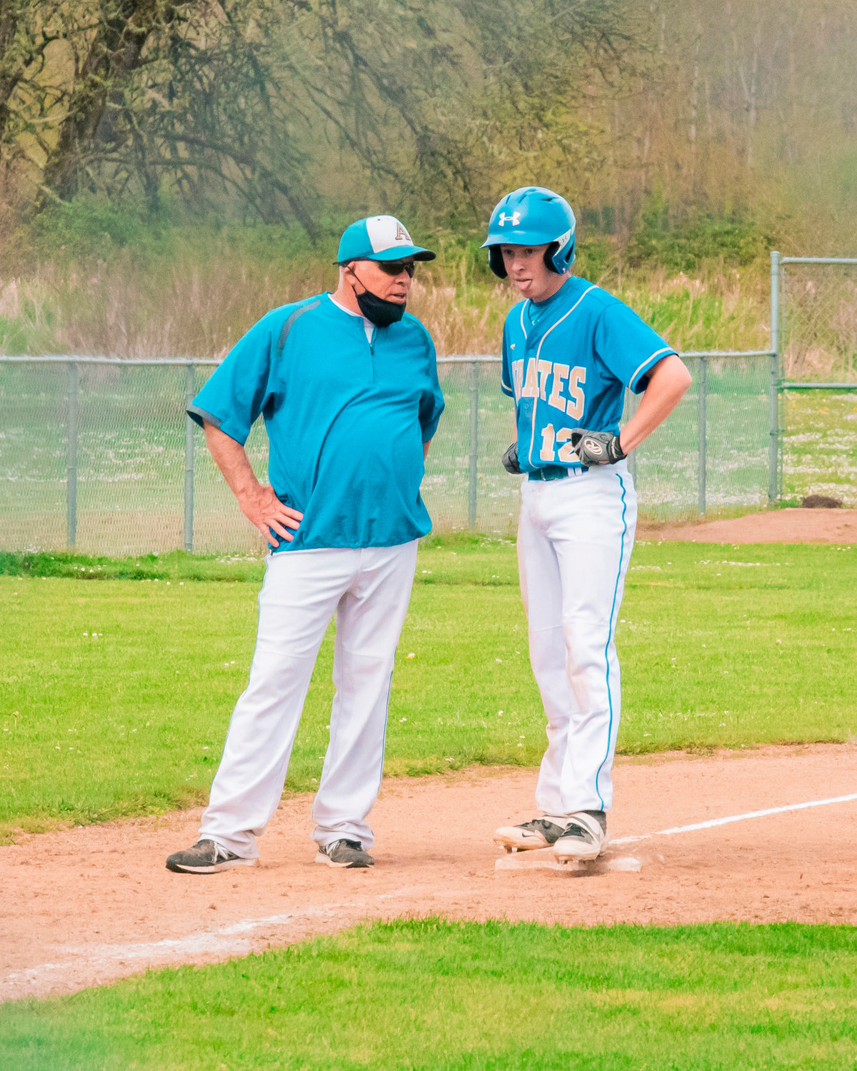 Adna’s Head Coach Jon Rooklidge talks to Nate Schuber (12) on third base during a game against Kalama on Thursday.