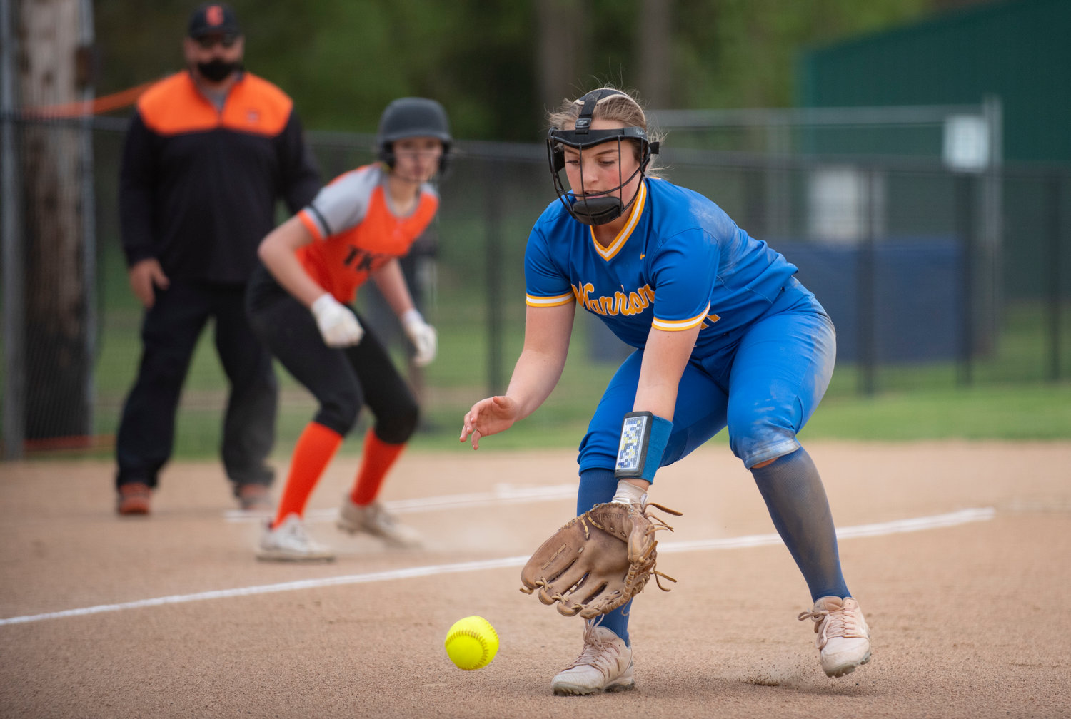 Rochester third baseman Callie Crawford fields a grounder with Centralia's Lauren Wasson behind her on the third base line.