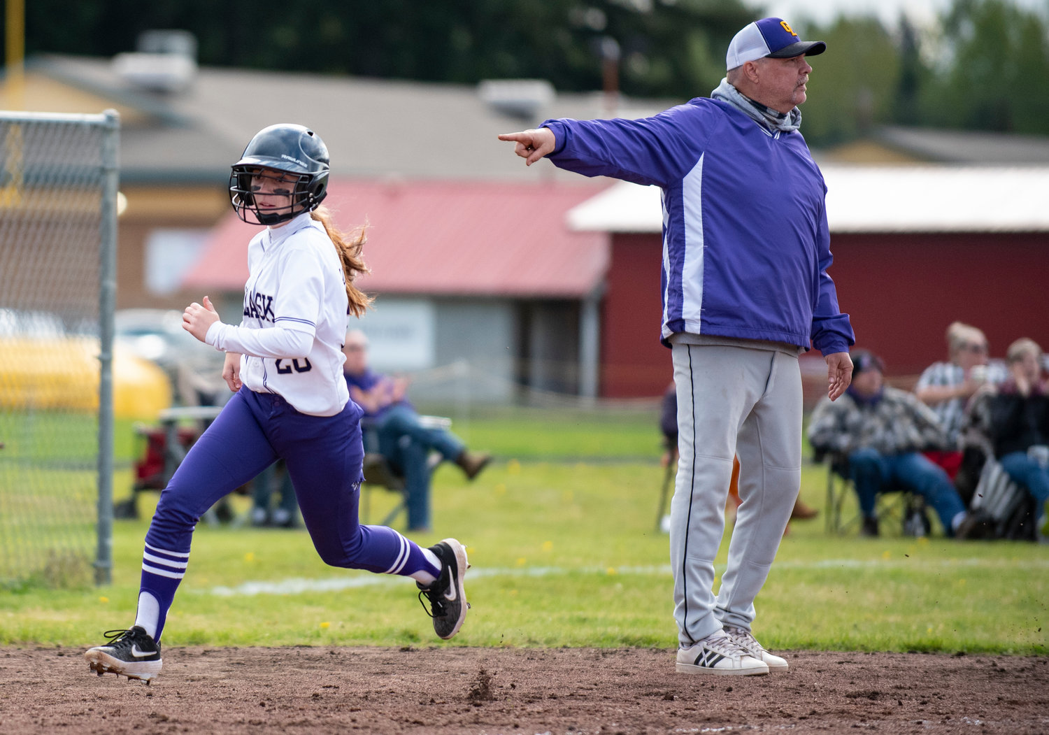 Onalaska's Taylor Babb rounds third to score while Loggers' coach Rich Teitzel waves her home.