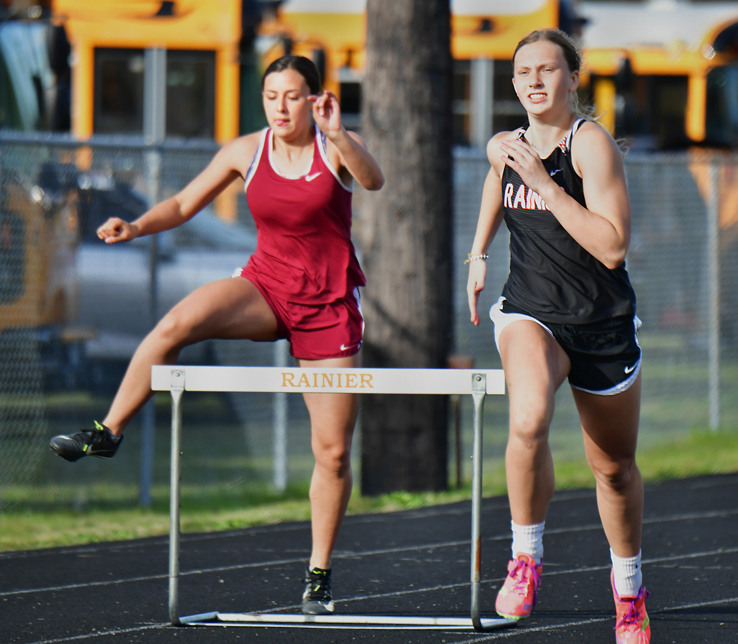 Rainier High School’s Kaeley Schultz, right, competes in the 300-meter hurdles on Thursday, April 29, during the WIAA District 4 Track & Field Championships at Rainier High School.