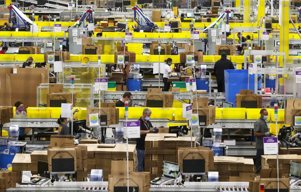 Employees at packing stations are seen at Amazon’s Kent fulfillment center, June 11, 2020.
