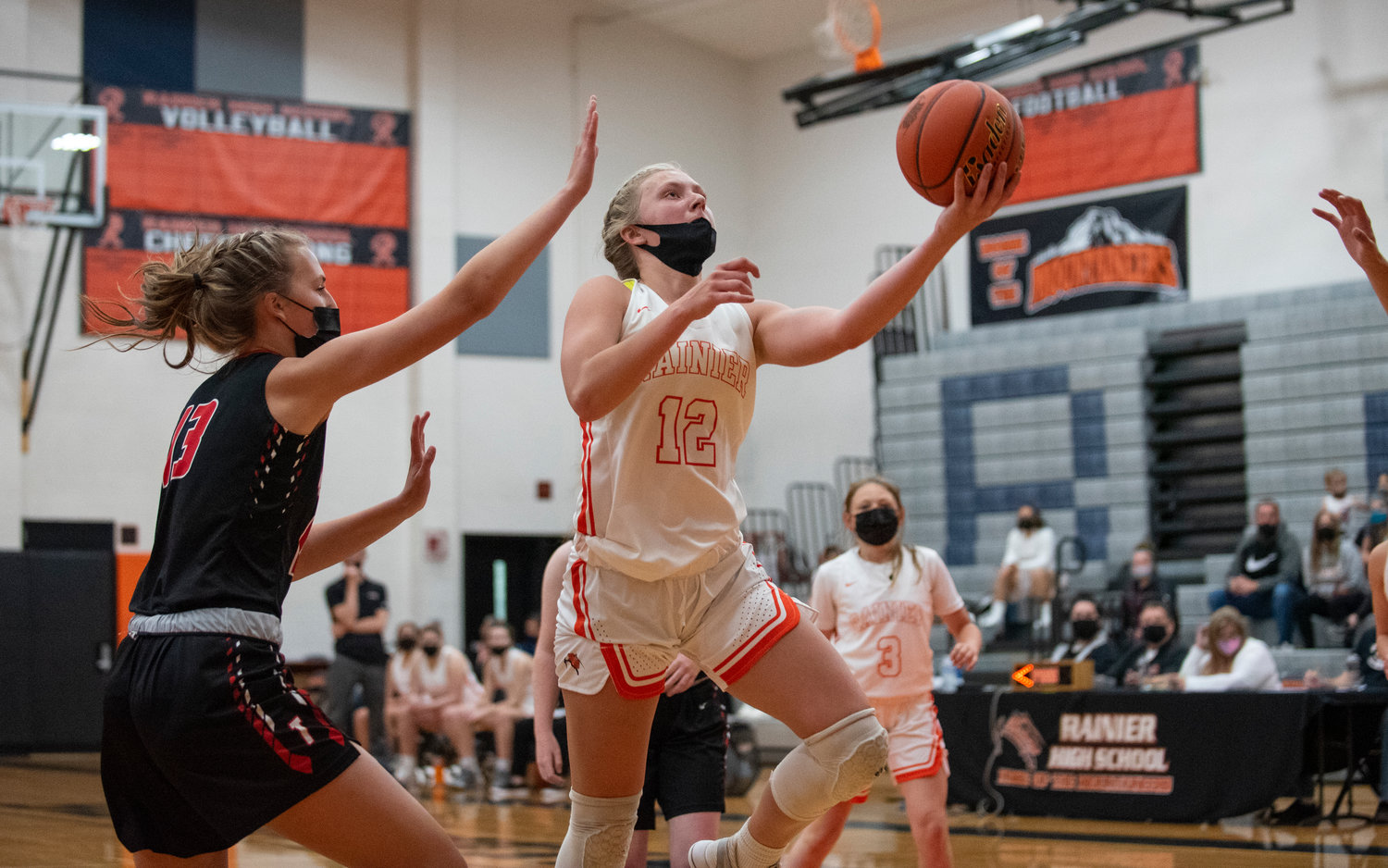 Rainier junior Kaeley Schultz (12) drives for a bucket against Tenino in the 2021 season opener Monday at home.