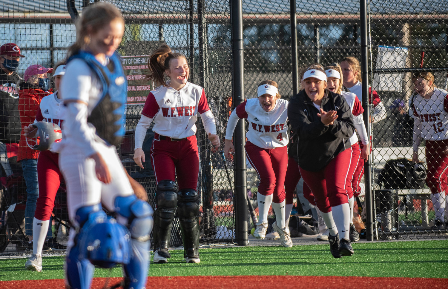 W.F. West players storm the field after Alisha Anderson's grand slam to give the Bearcats an 8-1 lead in the second inning on Thursday.