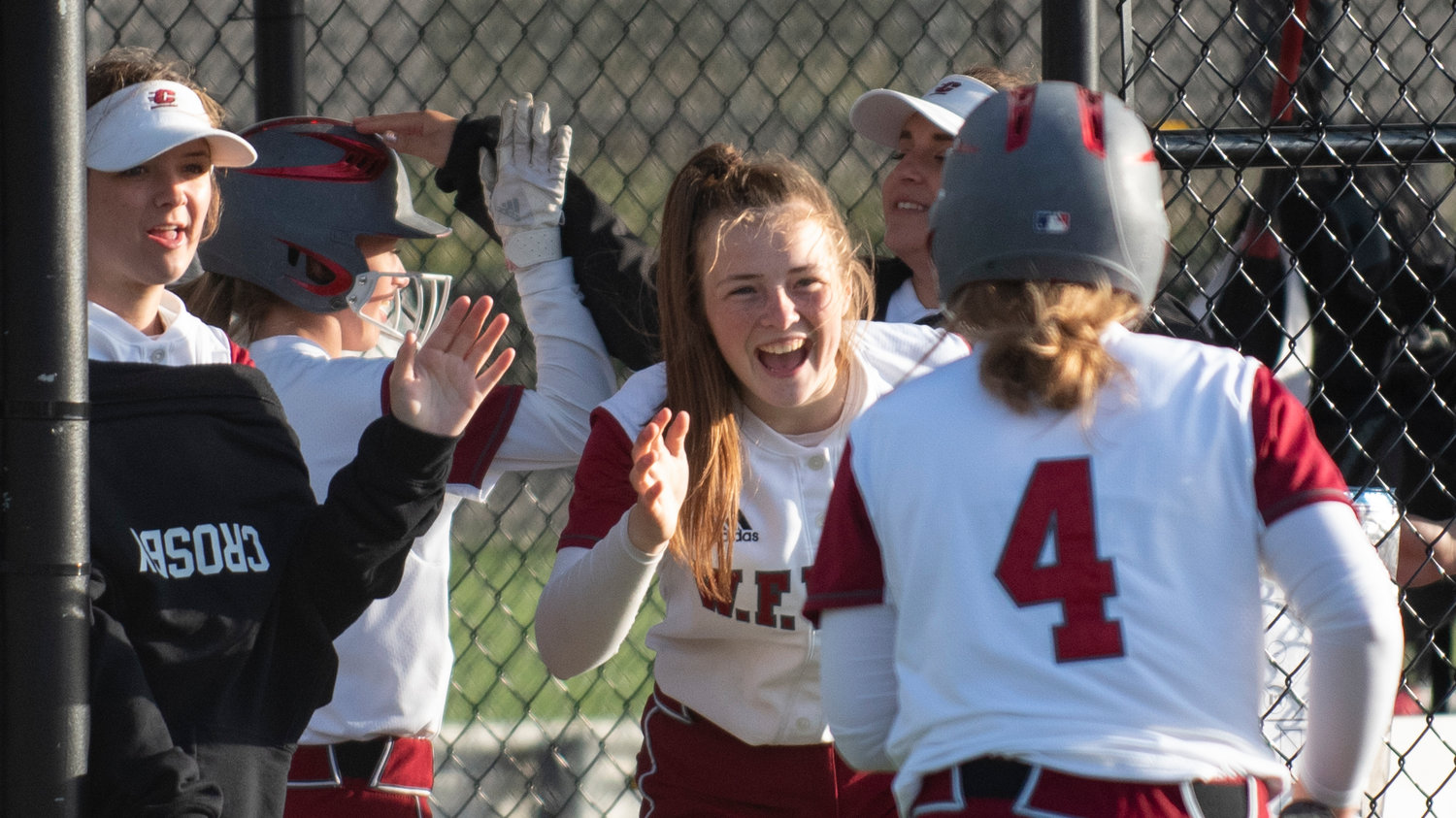 W.F. West players, including Rachel Gray, center, congratulate Lena Fragner (4) after scoring the first run of the district title game on Thursday.