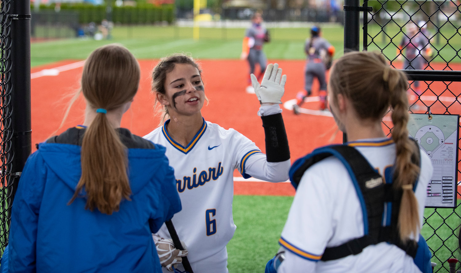 Rochester junior Sadie Knutson (6) high-fives teammates after scoring a run against Ridgefield in the district semifinals on Thursday.