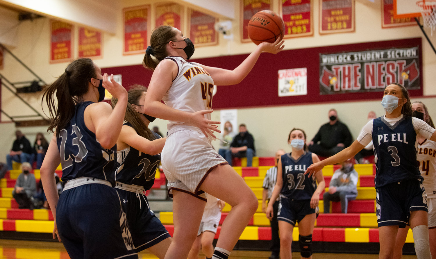 Winlock's Madison Vigre splits two Pe Ell defenders for two points on Saturday. Vigre finished with 22 points on the day.
