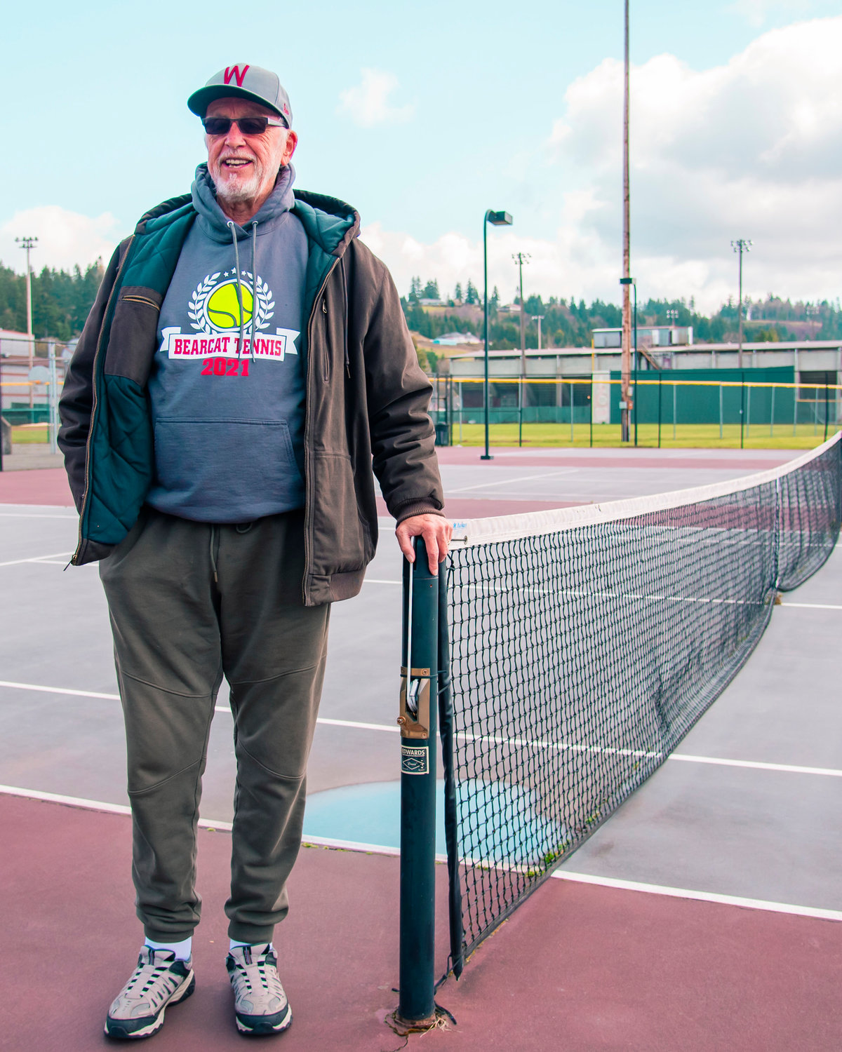 Jack State smiles while standing on a W.F. West school tennis court while talking about his years of coaching.