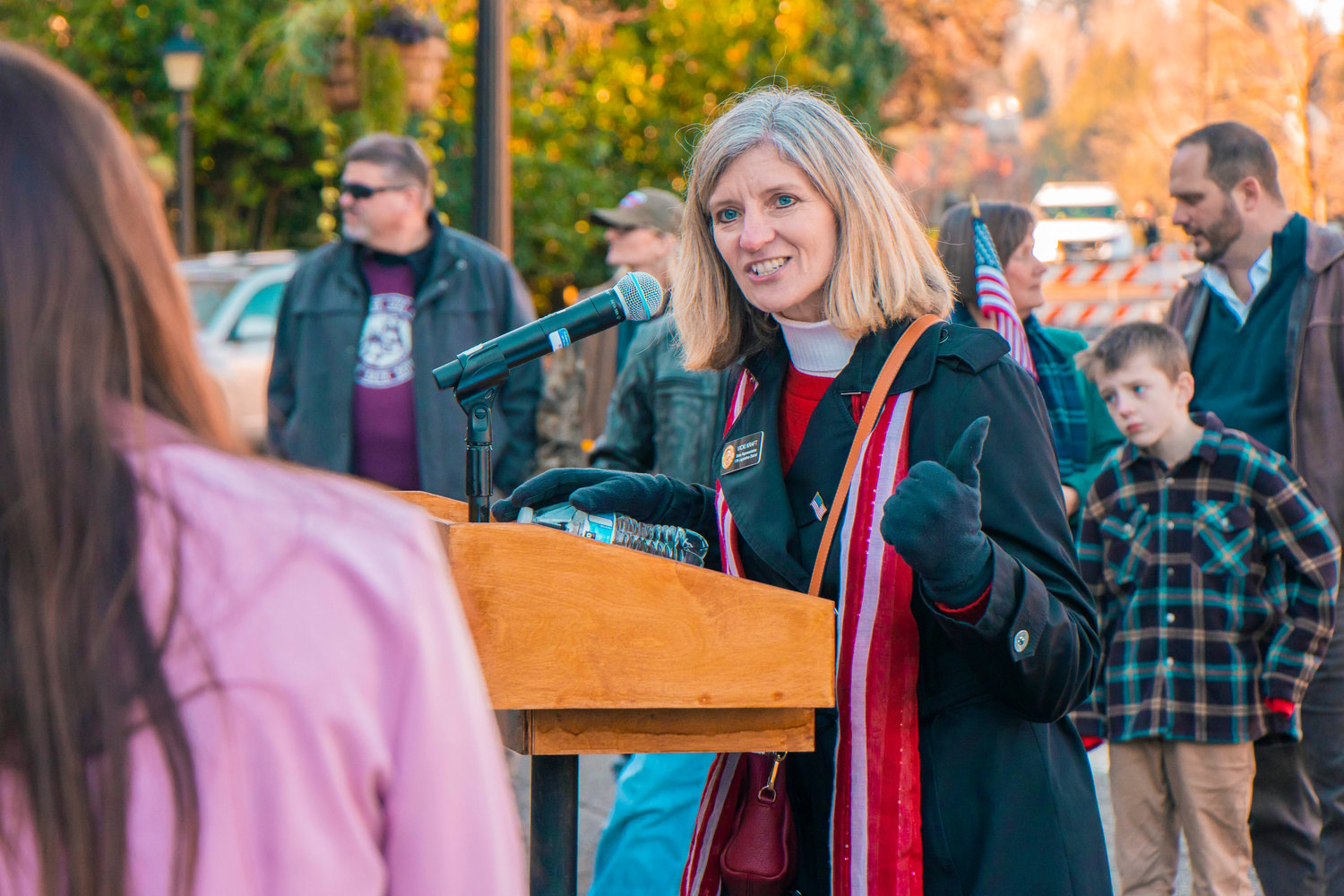Vicki Kraft introduces a student athlete to speak at the podium during a protest at the Washington State Capitol earlier this year.