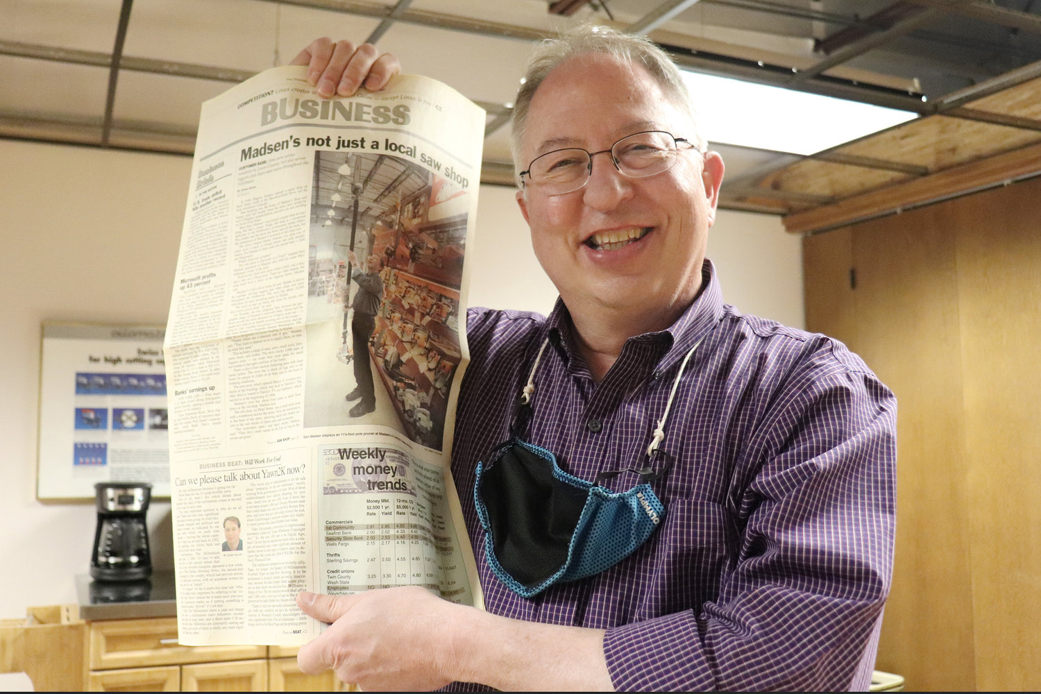 Sam Madsen holds up an old copy of The Chronicle that included coverage of Madsen’s Shop & Supply.