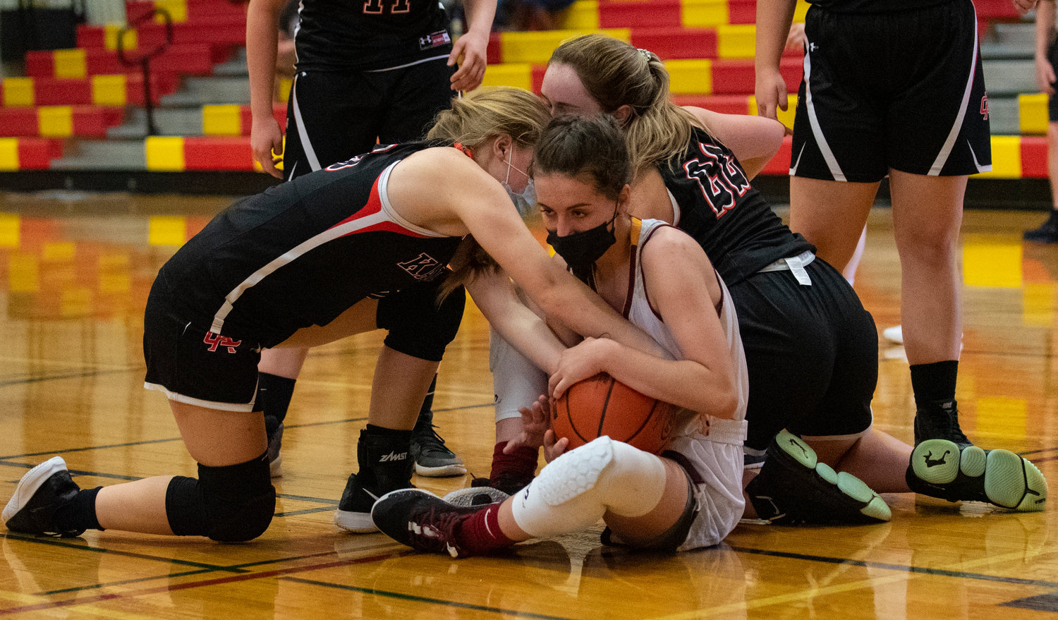 Winlock senior Elizabeth Wolfe fights for a loose ball with two Kalama players on Saturday.