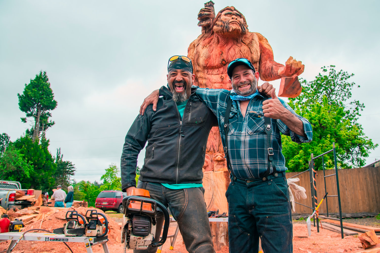 Tony Robinson and Bernie Madison pose for a photo in front of their 17-foot sasquatch carved with chainsaws into a sequoia 7-feet in diameter.