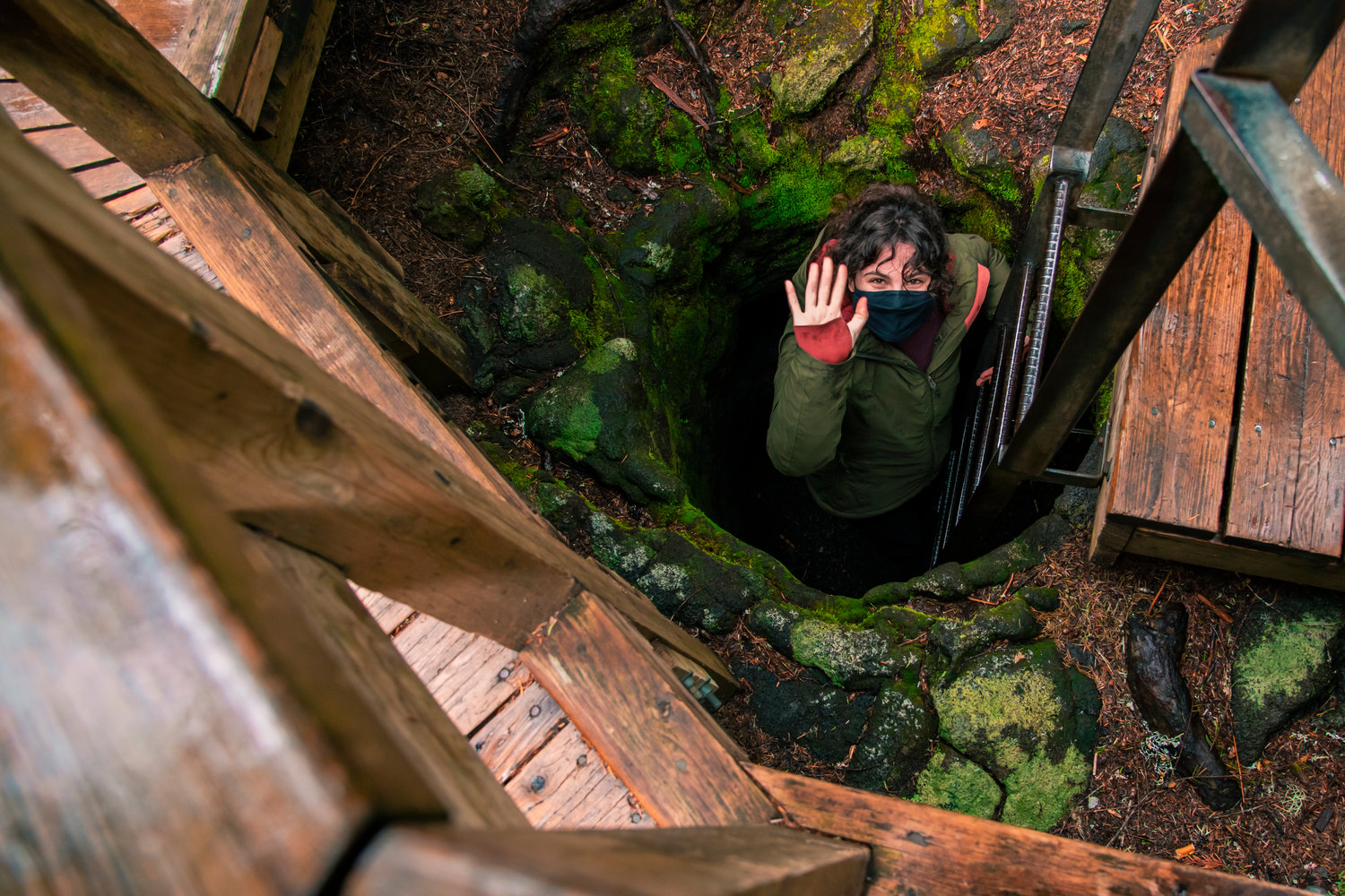 One tunnel, formed by fallen trees encompassed by lava at the Trail of Two Forests, created a claustrophobic crawl space visitors can now move through on their hands and knees. In this photo, Chronicle reporter Claudia Yaw waves while descending into the tunnel last week.