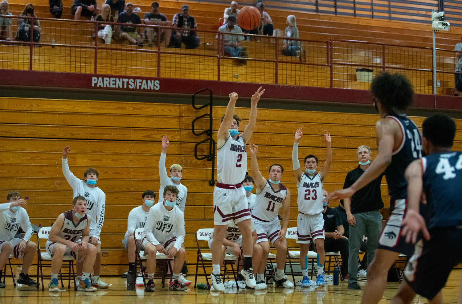 W.F. West senior Max Taylor (2) shoots a 3-pointer while the Bearcats' bench throws up the "three" sign.