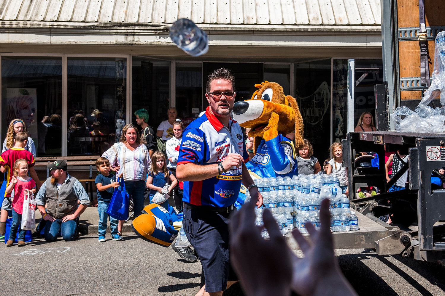 Aaron's employees pass out water bottles to attendees of the Egg Day parade in Winlock in 2019.